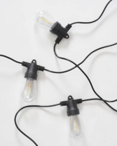 Brightech Ambience Pro solar-powered outdoor string lights with Edison-style bulbs on a patio