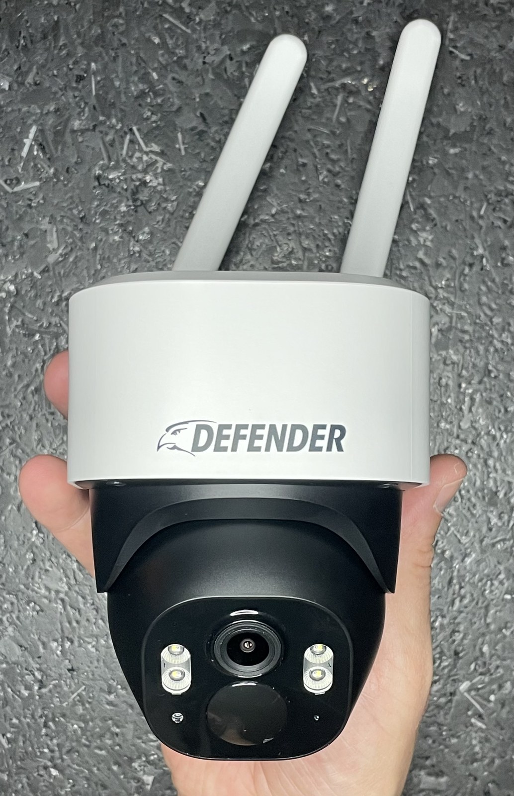 Defender 4G Frontier camera held in hand, showing the dual antennas and Defender branding on the camera head