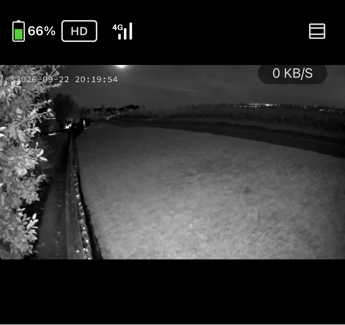 Infrared night vision footage from the Defender 4G Frontier's live view in the Empower app, showing a yard in black and white